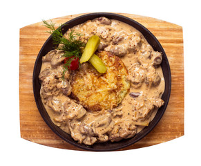 liver goulash with potato pancakes on a cast iron pan