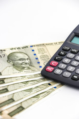 Close up view of calculator and brand new indian 500 rupees banknotes on white background.