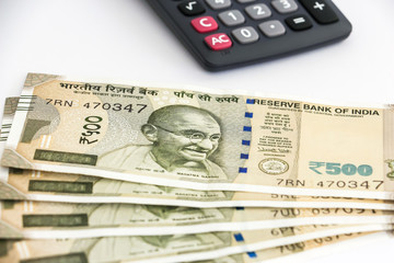 Fototapeta premium Close up view of calculator and brand new indian 500 rupees banknotes on white background.