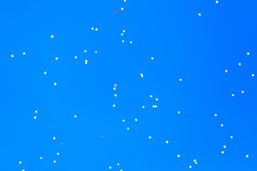 Naklejka na ściany i meble White balls flying in the blue sky