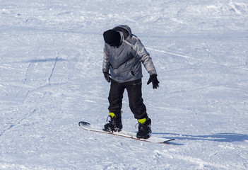 A man snowboarding a mountain in the snow in winter