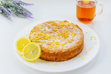 Homemade lemon pie with a cup of tea on a white wooden table