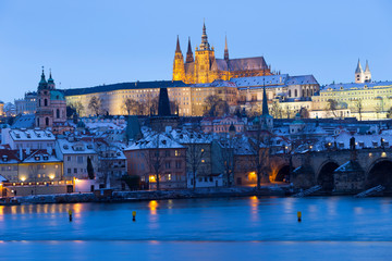 Night colorful snowy Christmas Prague Lesser Town with gothic Castle and Charles Bridge, Czech republic