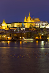 Fototapeta na wymiar Night colorful snowy Christmas Prague Lesser Town with gothic Castle and Charles Bridge, Czech republic