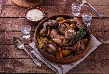 Rabbit baked with potatoe and herbs in a pot, copy space