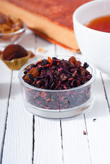 herbal tea, brown sugar, chocolate truffles and an old book on white wooden table