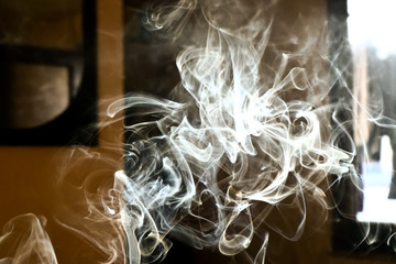 Smoke steam in room lighten by sun light, hazy steam curls for decorative special effect, abstract cigarette smoke background