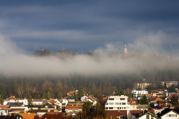 Houses with tiled roofs on the mountainside in winter season, Europe travel concept. Sunshine in Ljubljana, Slovenia
