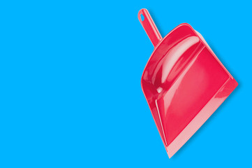 Empty single red plastic dustpan on blue background with copy space for your text