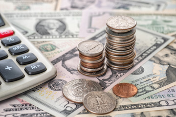 Fototapeta premium Coin stack with a calculator and banknotes