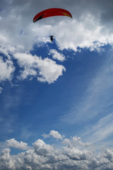 Paraglider flying over mountains during summer day