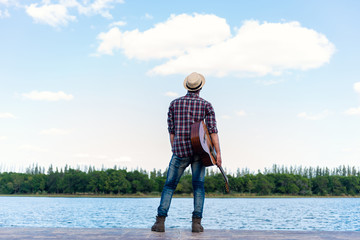 man with guitar on the river.