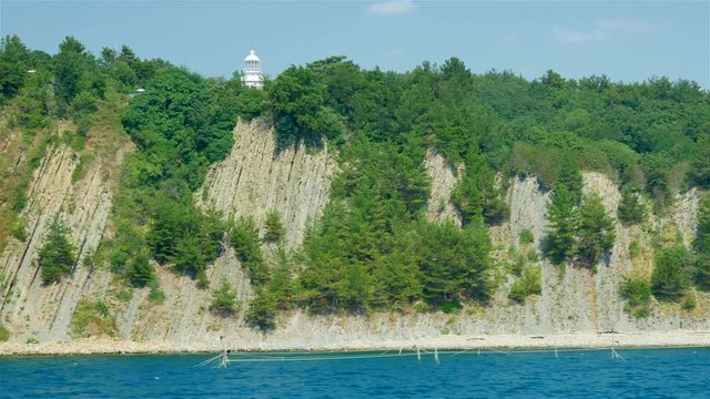Lighthouse on the rock near coast of the sea