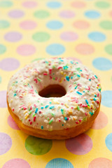 sugar glazed donut donuts decorated with colorful sprinkles over colorful background 