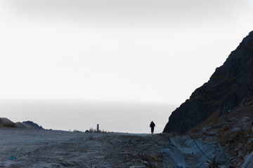 Adventurous man is standing on top of the mountain and enjoying the beautiful view during a vibrant sunset