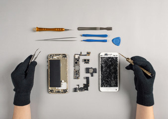 Technician or engineer disassembling components broken smartphone for repair or replace new part on...