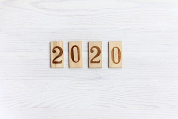 2020 number on wooden plates lying on a light wooden surface top view. Anniversary new year