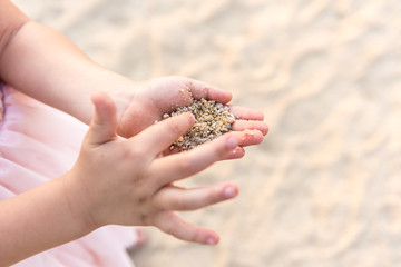 Close-up girl hands with sand on it