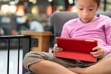 Little girl using computer tablet on sofa