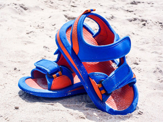 CHANCLAS DE PLAYA SOBRE LA ARENA DE LA ORILLA DEL MAR