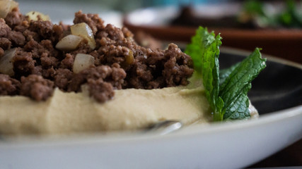 Plate of typical Lebanese hummus seasoned in various ways