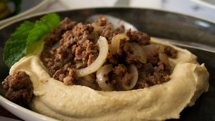 Plate of typical Lebanese hummus seasoned in various ways