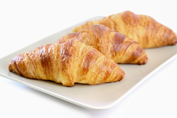  Three croissants on plate and white background