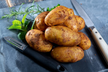 New harvest potatoes not washed with soil on table