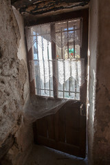 una vecchia porta in una vecchia casa abbandonata con le sue ragnatele - 241856118