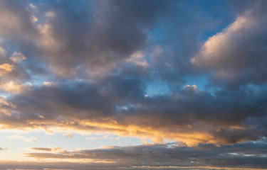 Obraz premium Beautiful colorful vibrant golden hour sunset skyscape with cloud formation and setting sun