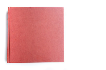Red leather covered wedding album lie on white background.