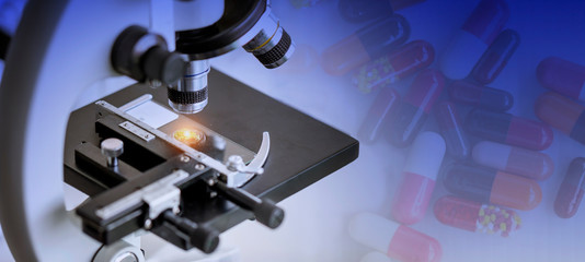 Close-up shot of microscope with metal lens at laboratory with medicine background