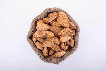 Almond nuts in jute sack bag with shell, top view photo