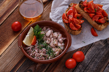 Baby squids with bruschettas and wine, top view