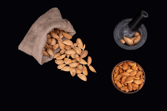 Top view photo of almond nuts, almonds with shell in jute overturned sack bag