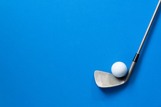 golf ball and golf club on blue background
