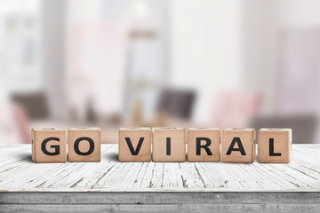 Go viral message sign on a wooden table - obrazy, fototapety, plakaty