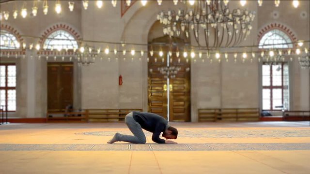 Muslim young male praying in mosque