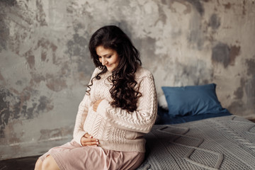 Beautiful pregnant woman in rose sweater