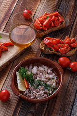Baby calamari in olive oil with bruschettas and wine