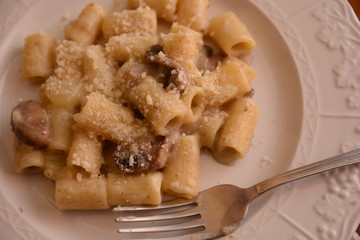 piatto di pasta italiano mezzemaniche alla crema di funghi besciamella e formggio mozzarella e parmiggiano