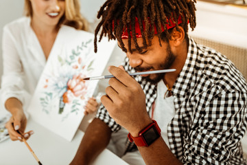 Close up of young stylish dark-haired art student with dreadlocks