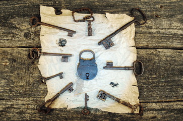Old lock and keys.Wooden background.Parchment
