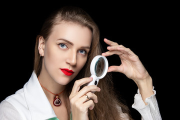 Beautiful woman doctor holding magnifying glass
