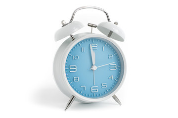 Table alarm clock with time 1 minute to 12 hours with blue clock face, 11.59 AM PM, on white background