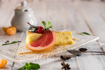 Delicious dessert cheesecake with fruits on wooden background