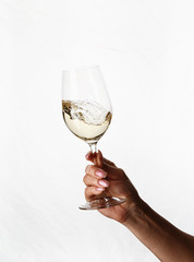 hand holding a glass of white wine