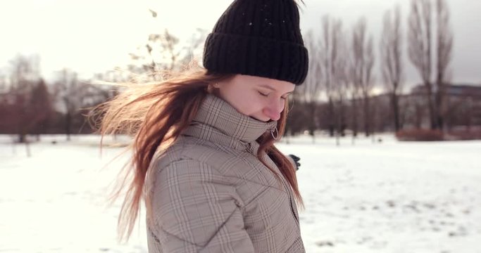 4K Footage of happy young girl walking and jumping on the park with snow and sun shine weather. - Video