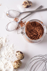 cocoa, eggs, flour and sugar on a white background top view.