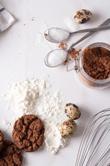 chocolate cookies and baking ingredients on white background top view.